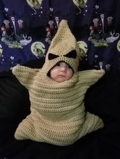 a baby wrapped in a crochet costume