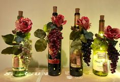 three wine bottles decorated with flowers and leaves