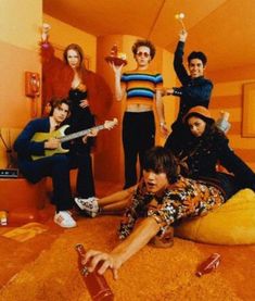 a group of young people sitting around each other in a room with orange walls and flooring