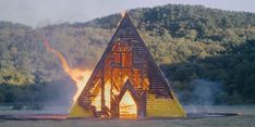 a large triangle shaped structure with flames coming out of it