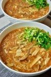 two white bowls filled with soup on top of a table