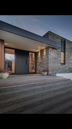 a modern house with steps leading up to the front door