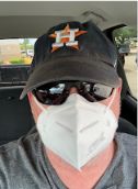 a man wearing a face mask in the back seat of a car