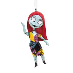 a cartoon character ornament hanging from a string on a white background with red hair