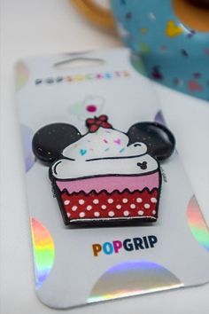 a minnie mouse pin with a cupcake on it's back and the name popgrip