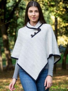 If you are tired of dull sweaters and want to refine your looks, then you will not go wrong with this Herringbone Cape! Flowy and chic, this piece is made of Merino wool blend that will keep you warm and cozy through the fall and winter seasons. As a cape, it also features a loose yet neatly tapered look that wonderfully frames any shape while offering great breathability for comfort and layering with other pieces. Catching the eye from any angle on this poncho is a striking geometric herringbone design that beautifully sweeps across the piece from left to right. Complementing the elegance of the herringbone pattern is a lovely asymmetric folded collar that is accented with three brown football buttons that highlight the neck for a dainty effect. This versatile cape can take you from being Football Buttons, Poncho For Women, Poncho Shawl, Knitted Cape, Herringbone Design, Wool Poncho, Irish Gifts, Knitted Poncho, Herringbone Pattern