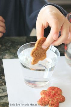 a person dipping crackers into a glass of water