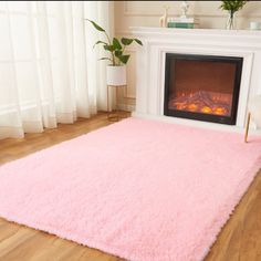 a living room with a pink rug and fireplace