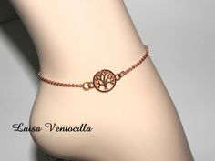 a close up of a person's foot with a tree of life bracelet on it