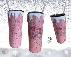 three pink tumblers with white frosting and straws on them in the snow