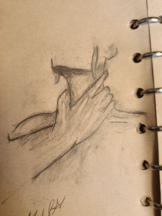 a pencil drawing of a hand holding something in it's right hand, on top of a notebook