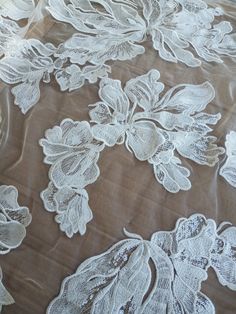 white lace with flowers and leaves on a brown clothed tablecloth, as seen from above