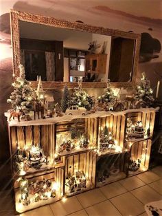 a christmas display with lighted trees and deers on it in front of a mirror