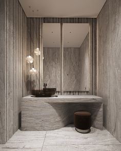 a bathroom with marble walls and flooring has a large mirror on the wall above it