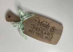 a wooden cutting board with the words meals and memories are made here