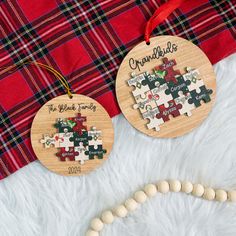 two personalized wooden christmas ornament hanging on a white furnishing next to a red and black plaid blanket