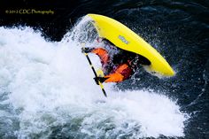 a man riding on the back of a yellow kayak