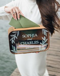 a woman is holding a box with some books on it that says sophia and charles