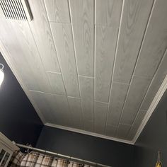 a bathroom with wood paneling on the ceiling