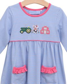 Get ready for a day on the farm with this adorable blue striped dress! With a cute tractor, cow, and barn applique, this dress is perfect for your little one. The pink ruffled front pockets add a charming touch, making this dress a must-have for farm. Playful Cotton Twirl Dress With Ruffles, Farm Applique, Playful Cotton Ruffle Twirl Dress, Rainbow Cotton Playtime Dress, Blue Cotton Smocked Playtime Dress, Playful Pink Unicorn Print Dress, Style Bubble, Bloomers Shorts, Blue Striped Dress