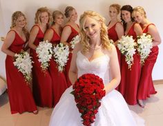 a bride and her bridal party in red dresses