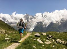 a man running on a trail with mountains in the background