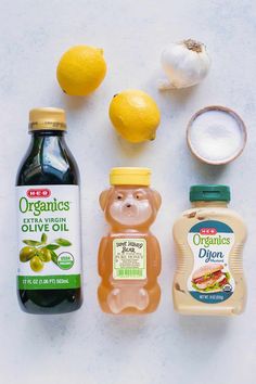 the ingredients for an olive oil and lemon salad laid out on a white surface