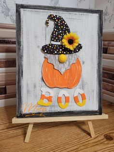 a painted sign with a pumpkin and witch hat on it