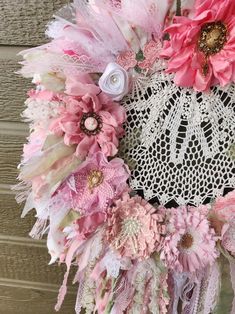 a wreath made out of pink flowers and lace