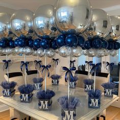 a table topped with lots of silver and blue balloons