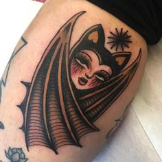 a woman's leg with a bat tattoo on it