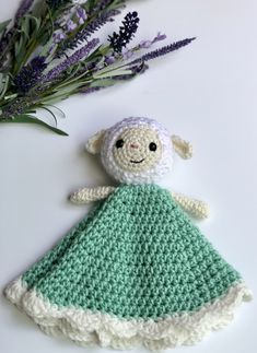 a crocheted stuffed animal sitting on top of a table next to lavender flowers