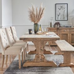 a dining room table with four chairs and a bench in front of it on a rug