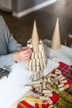 a person is making a christmas tree out of wine corks and other crafting supplies