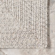 the rug is made out of white and grey herringbones on a marble floor