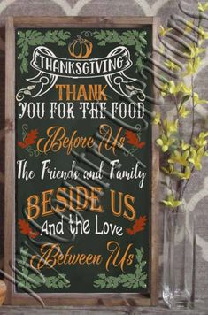 a chalkboard sign with thanksgiving sayings on it next to a vase filled with flowers