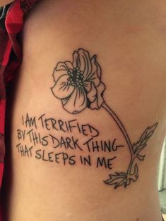 i am terrified by this dark thing that sleeps in me tattoo on the back of a woman's stomach