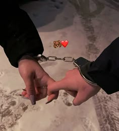 two people holding hands with hearts attached to them