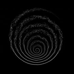 an abstract black and white photo with spirals in the middle on a dark background