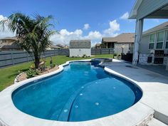 a backyard with a swimming pool and landscaping