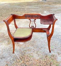 an old wooden bench with a green cushion on it