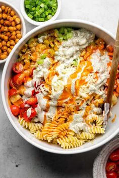 a bowl filled with pasta salad next to other bowls