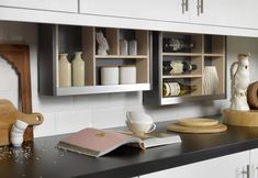 a kitchen counter with books, vases and other items on it