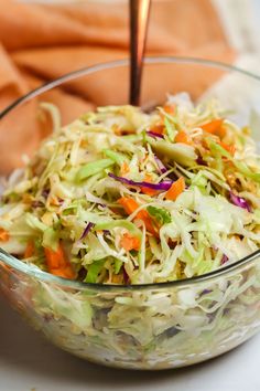 a glass bowl filled with coleslaw and carrots