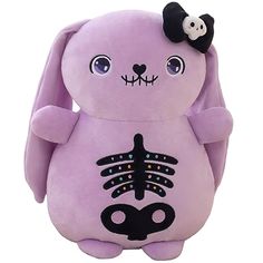 a purple stuffed animal with a black bow on it's head and bones in the shape of a skeleton