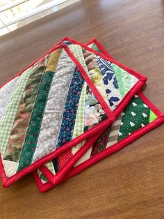 four quilted placemats sitting on top of a wooden table