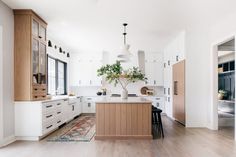 a kitchen with wooden floors and white cabinets