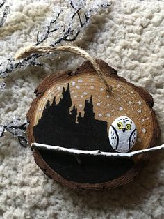 an owl ornament is hanging on a piece of wood