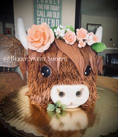 a cake made to look like a cow with flowers on its head