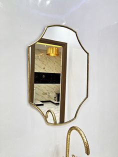 a bathroom sink sitting under a mirror next to a faucet mounted on a wall